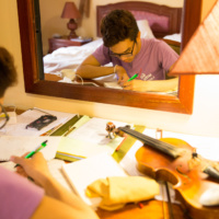 Anousone Pranikay from Lao is composing music in his room during the workshop. He majors violin atLao National Sch